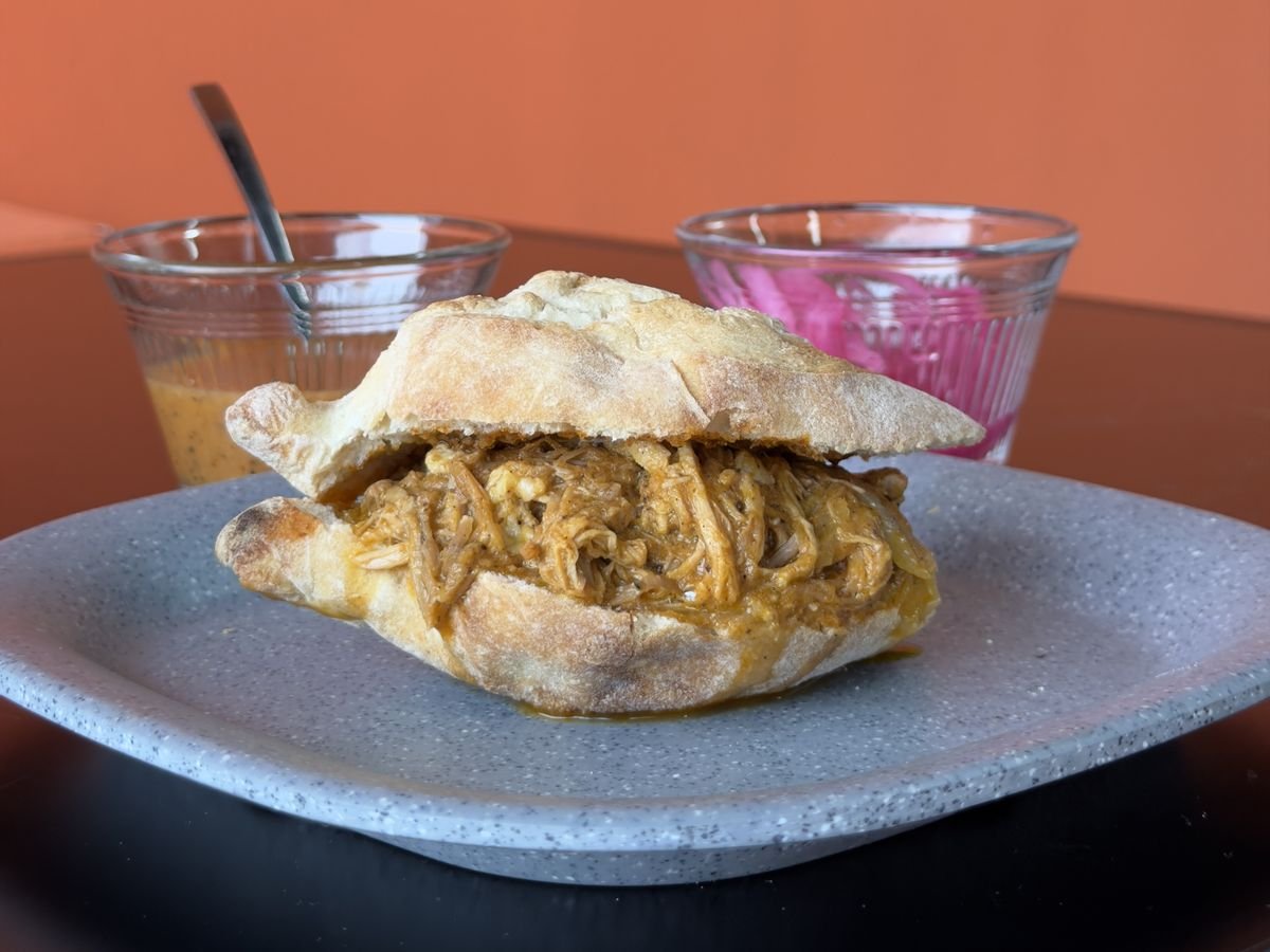 Torta de cochinita pibil en bolillo con salsa y cebolla morada curtida